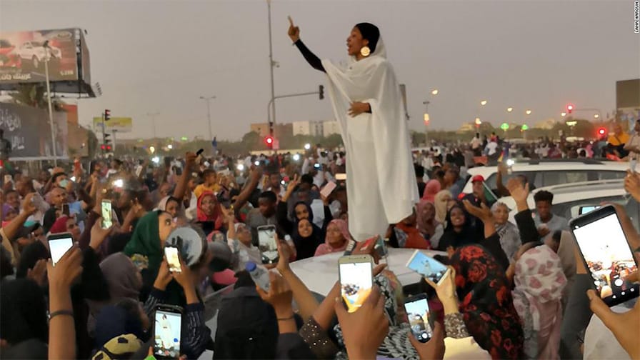 Alaa Salah leads a crowd of protesters in Sudan with chants of "Thawra!" - Revolution!