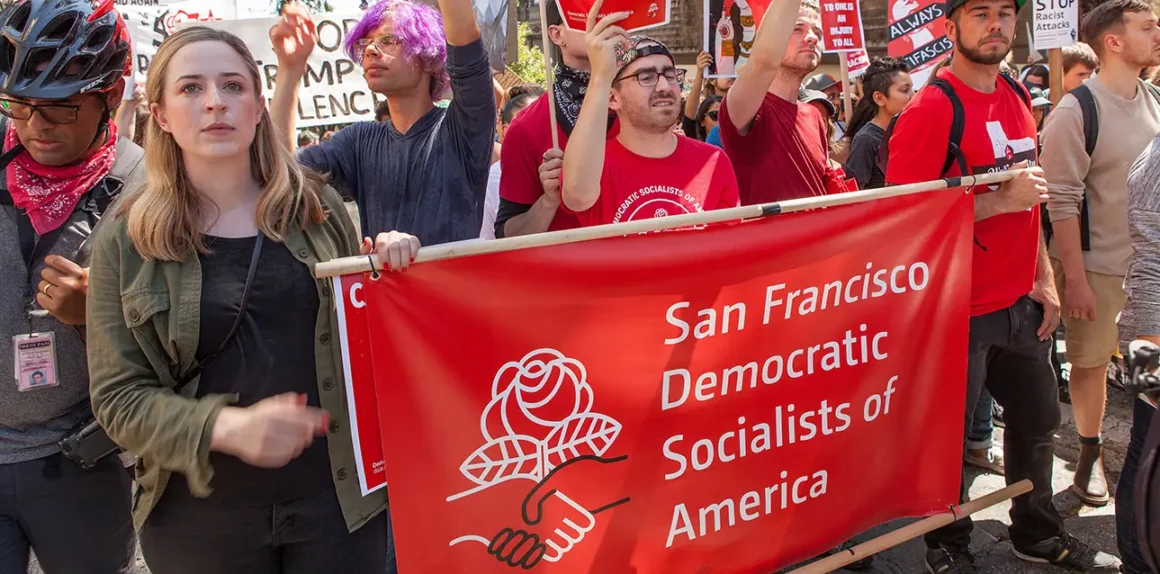 DSA members on a counter-demonstration against the far right, in San Francisco. Holding a red banner.