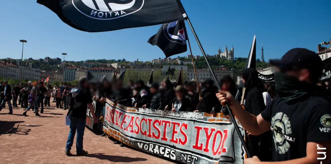 Antifascist activists in Lyon, France, with a banner, and waving the black antifascist action flag
