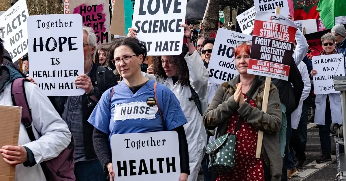 NHS workers and supporters carrying multiple Together Alliance placards, including ‘Together: health not hate’, during the anti-racist march in London.